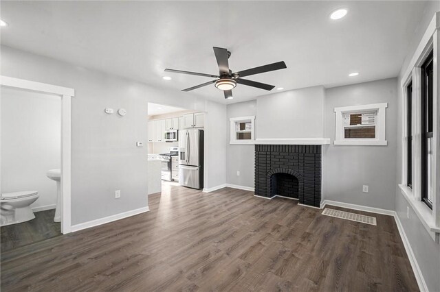 unfurnished living room featuring ceiling fan, a fireplace, and hardwood / wood-style flooring