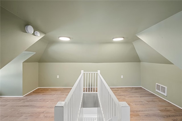 additional living space featuring lofted ceiling and hardwood / wood-style flooring