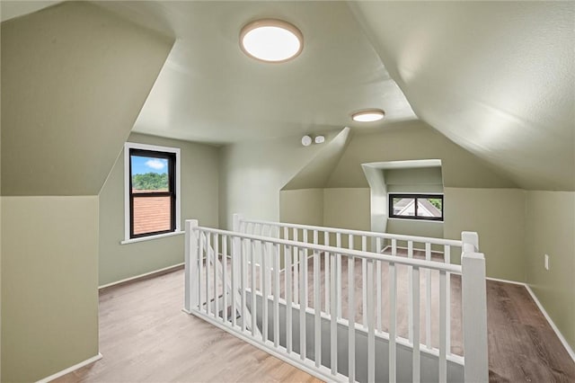 additional living space featuring vaulted ceiling and hardwood / wood-style floors