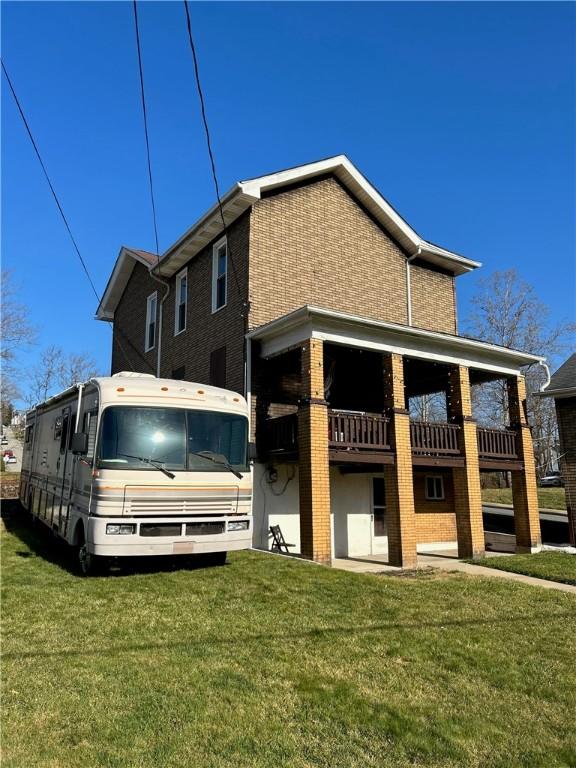 rear view of property with a lawn