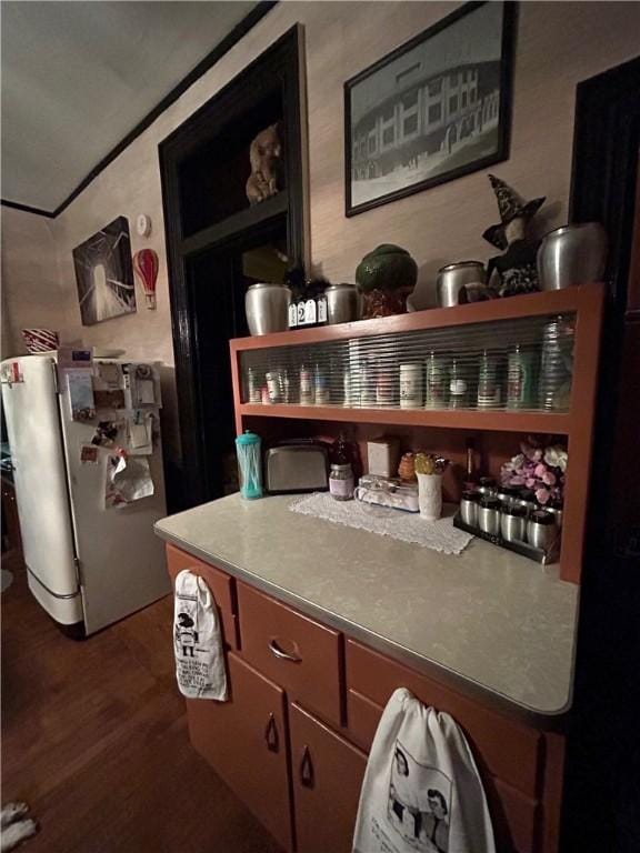 bar with dark wood-type flooring and fridge