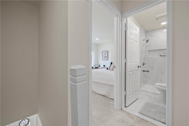 bathroom with a tile shower and toilet