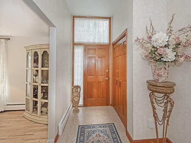 foyer with baseboard heating and light hardwood / wood-style flooring