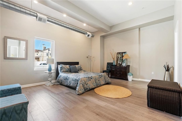 bedroom featuring hardwood / wood-style flooring and an AC wall unit