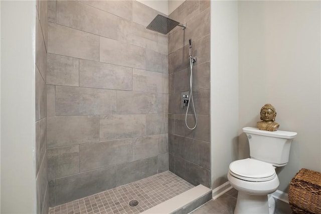 bathroom featuring tiled shower and toilet