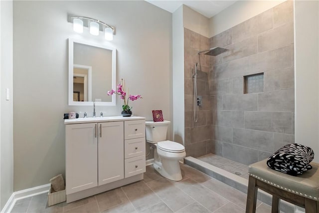 bathroom featuring vanity, tiled shower, and toilet