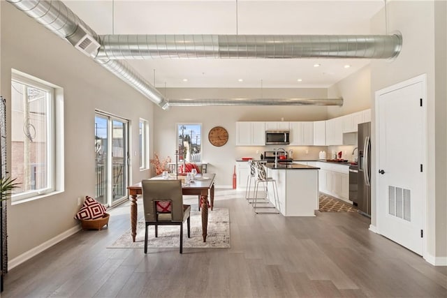 dining room with a high ceiling and hardwood / wood-style floors