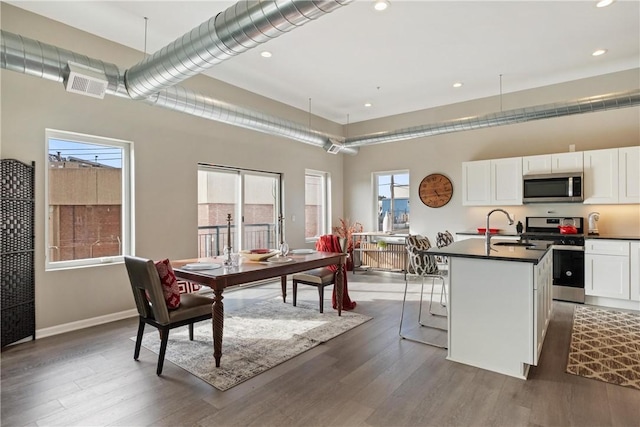 dining room with dark hardwood / wood-style flooring, sink, and a high ceiling