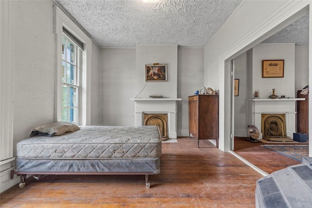 bedroom with hardwood / wood-style floors and a textured ceiling