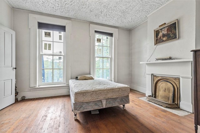 bedroom with light hardwood / wood-style flooring and a textured ceiling