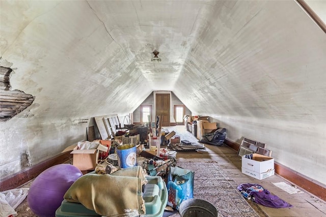 additional living space with hardwood / wood-style flooring and vaulted ceiling