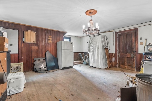 miscellaneous room featuring wood walls, light hardwood / wood-style floors, and a chandelier