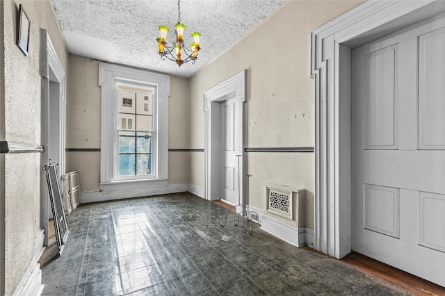 unfurnished dining area featuring a textured ceiling and an inviting chandelier