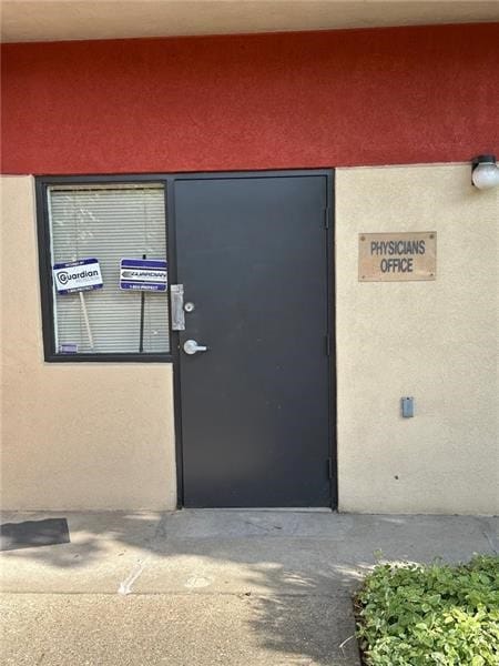 property entrance with stucco siding