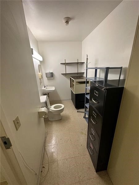 bathroom featuring baseboards, toilet, and tile patterned floors