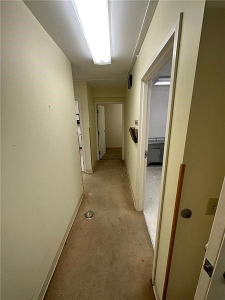 hallway with light carpet and baseboards