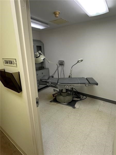 exercise room with baseboards and tile patterned floors