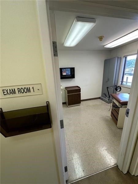 hall featuring baseboards and tile patterned floors