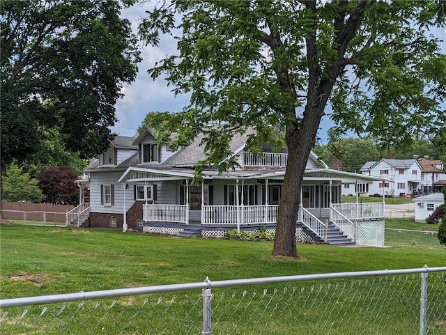 rear view of property featuring covered porch and a yard