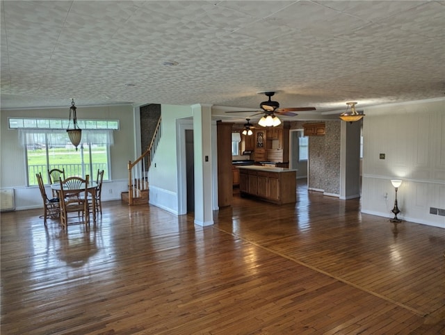 unfurnished living room with dark hardwood / wood-style floors and ceiling fan