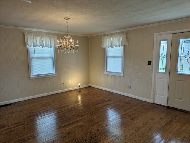 foyer entrance with a notable chandelier, a wealth of natural light, dark hardwood / wood-style floors, and crown molding