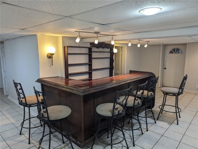 bar featuring pendant lighting, light tile flooring, rail lighting, and a drop ceiling