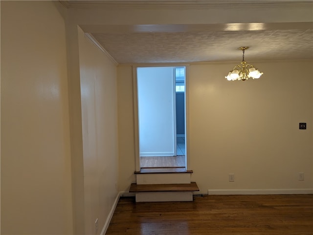 unfurnished room featuring a chandelier, ornamental molding, and hardwood / wood-style floors