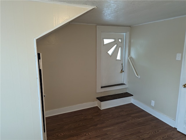 staircase featuring a textured ceiling and dark hardwood / wood-style floors