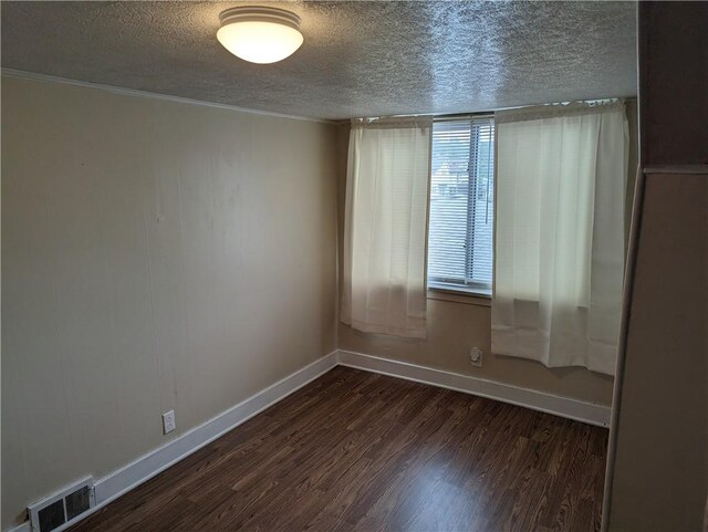 empty room featuring a textured ceiling and dark wood-type flooring