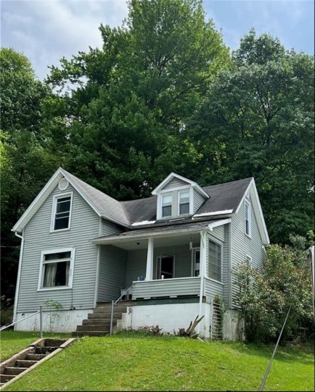 view of front facade with a front yard and covered porch