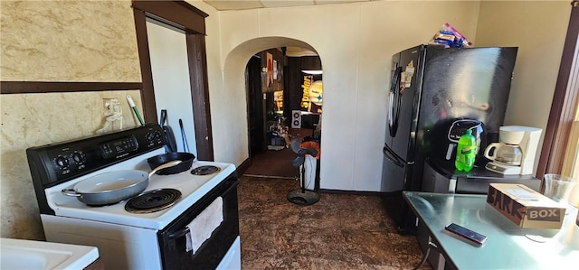 kitchen featuring black refrigerator and white electric stove