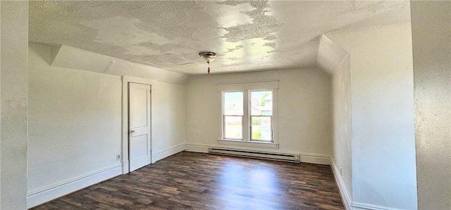 spare room featuring dark hardwood / wood-style flooring, lofted ceiling, a textured ceiling, and a baseboard heating unit