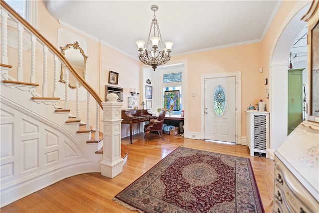 foyer featuring crown molding, a chandelier, and hardwood / wood-style flooring