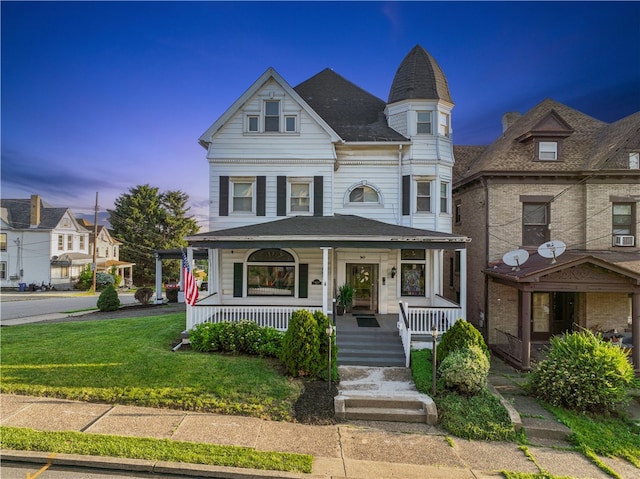 victorian-style house with a lawn and covered porch