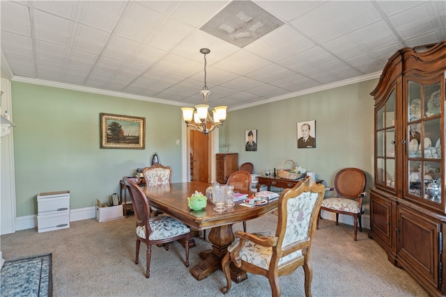 carpeted dining space featuring crown molding and a chandelier