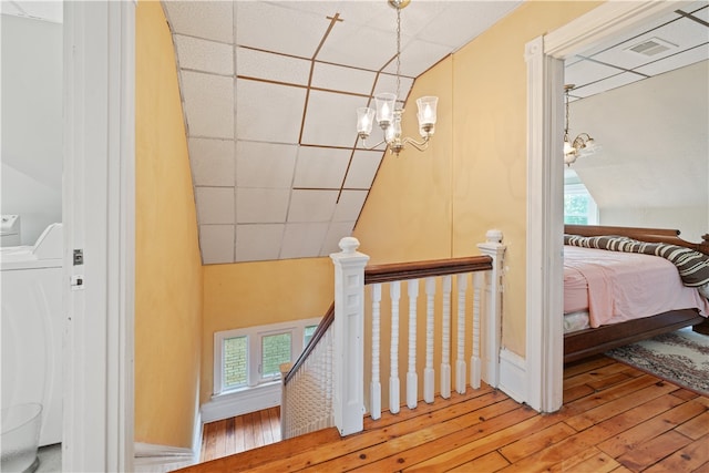 stairs with a drop ceiling, wood-type flooring, and washer / clothes dryer