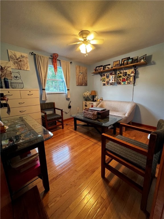 living room featuring wood-type flooring and ceiling fan