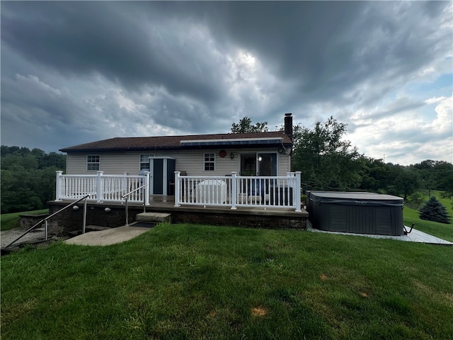 view of front of home with a deck, a hot tub, and a front yard