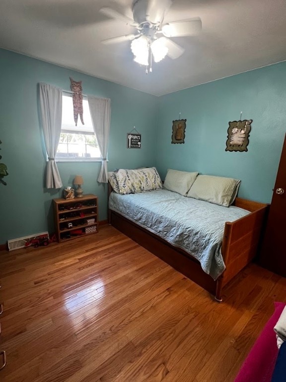 bedroom with ceiling fan and hardwood / wood-style flooring