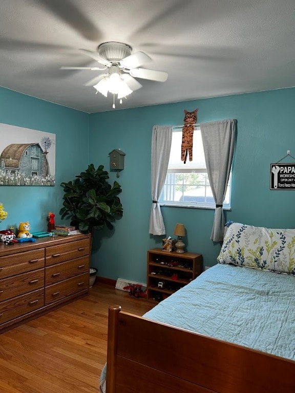 bedroom with light hardwood / wood-style flooring and ceiling fan