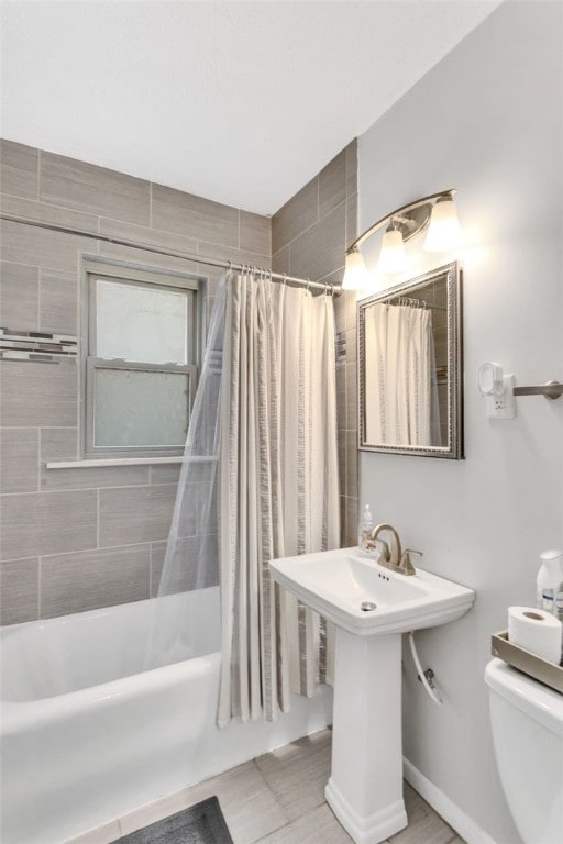 full bathroom with sink, shower / bathtub combination with curtain, and toilet