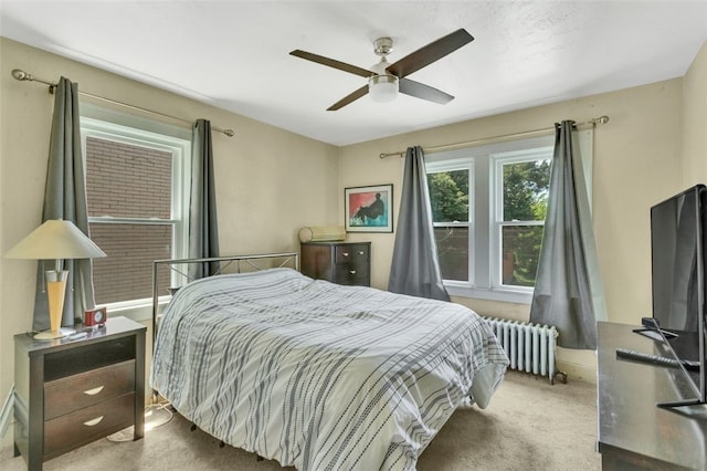 carpeted bedroom with ceiling fan and radiator