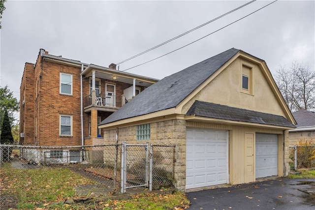 view of side of property with a garage and a balcony