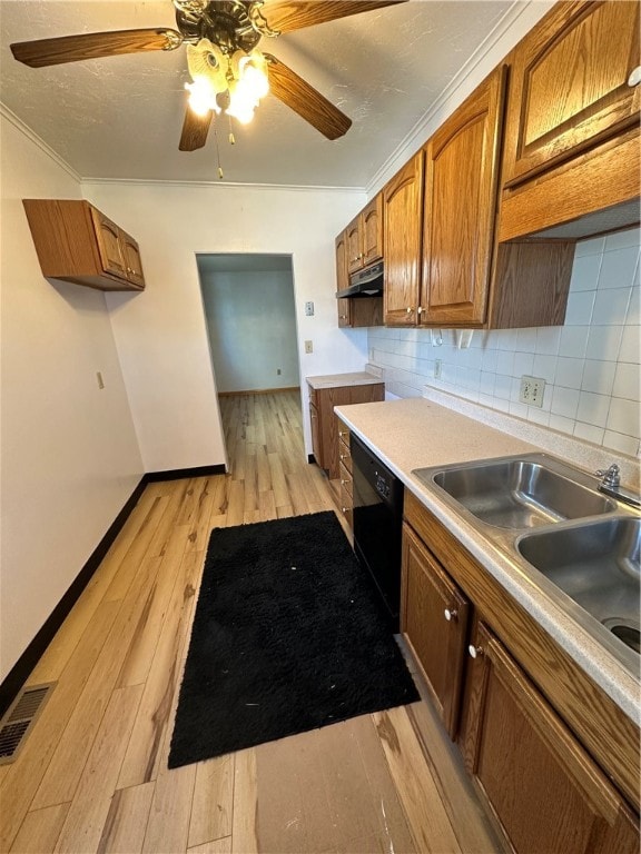 kitchen featuring crown molding, light wood-type flooring, ceiling fan, backsplash, and dishwasher