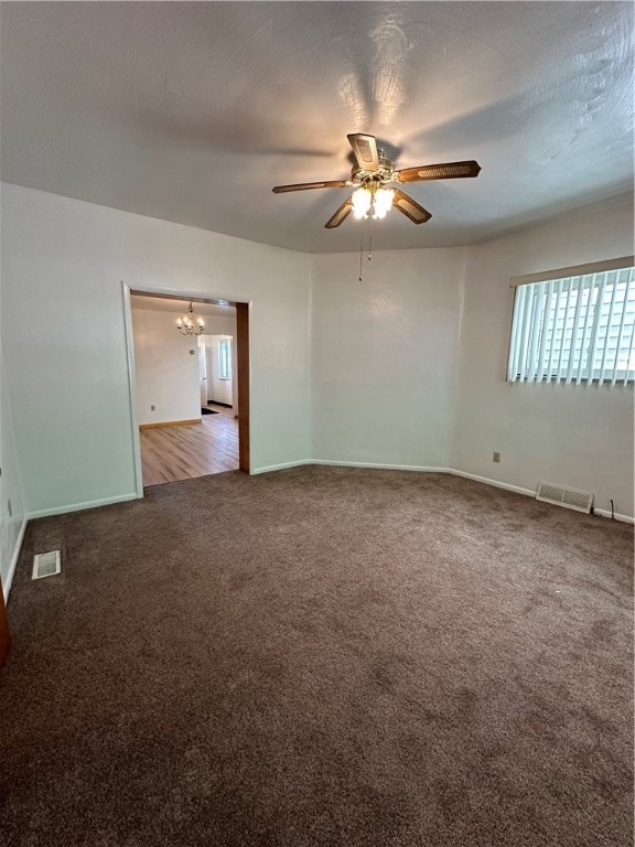 empty room with carpet floors and ceiling fan with notable chandelier