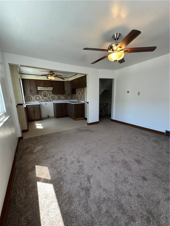 unfurnished living room with carpet floors and ceiling fan