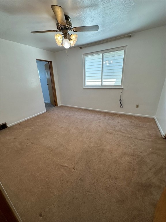 spare room featuring ceiling fan and carpet floors