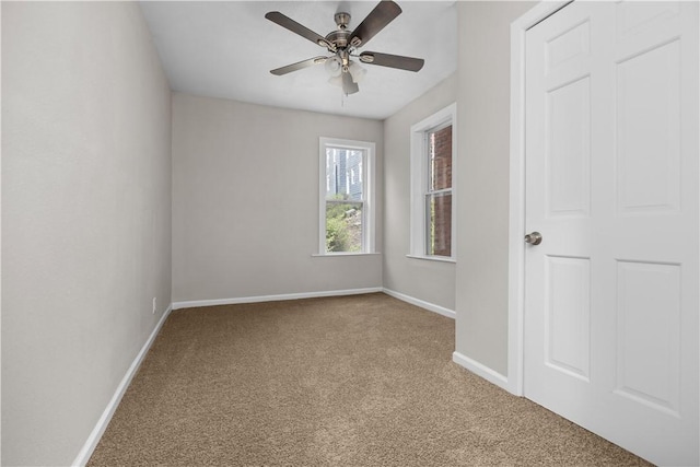 carpeted spare room featuring ceiling fan