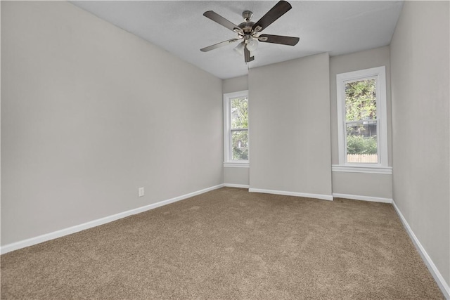 carpeted empty room with ceiling fan and a healthy amount of sunlight