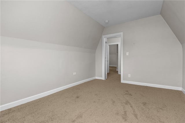 additional living space featuring lofted ceiling and carpet flooring